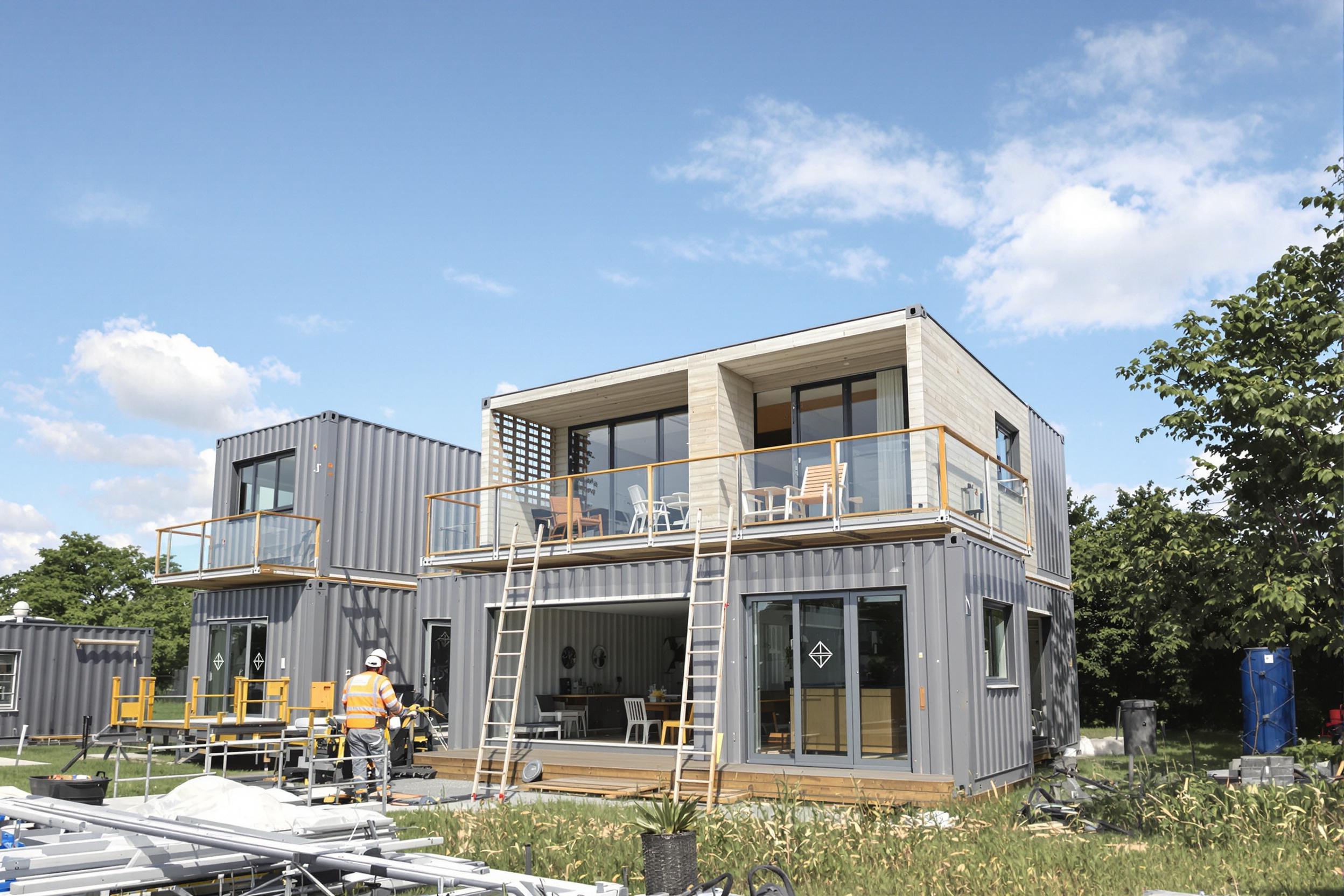 Chantier de maison container avec grue et modules positionnés